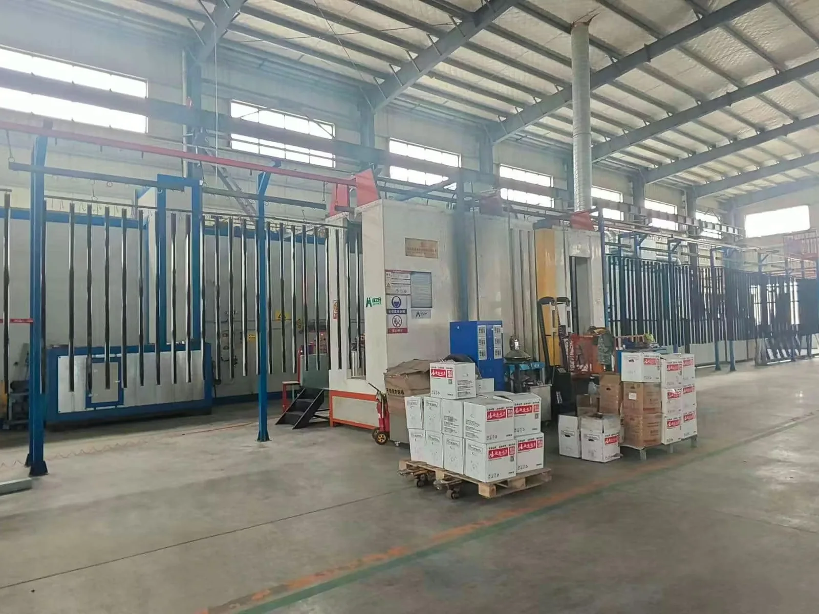Fence components moving through a powder coating production line